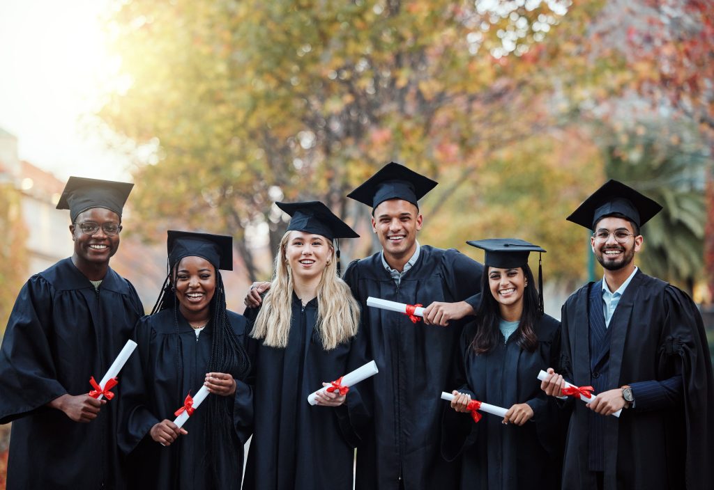 International students smiling together for a photo celebrating graduation